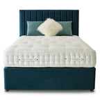 White mattress on a dark blue bed frame with decorative pillows on a white background