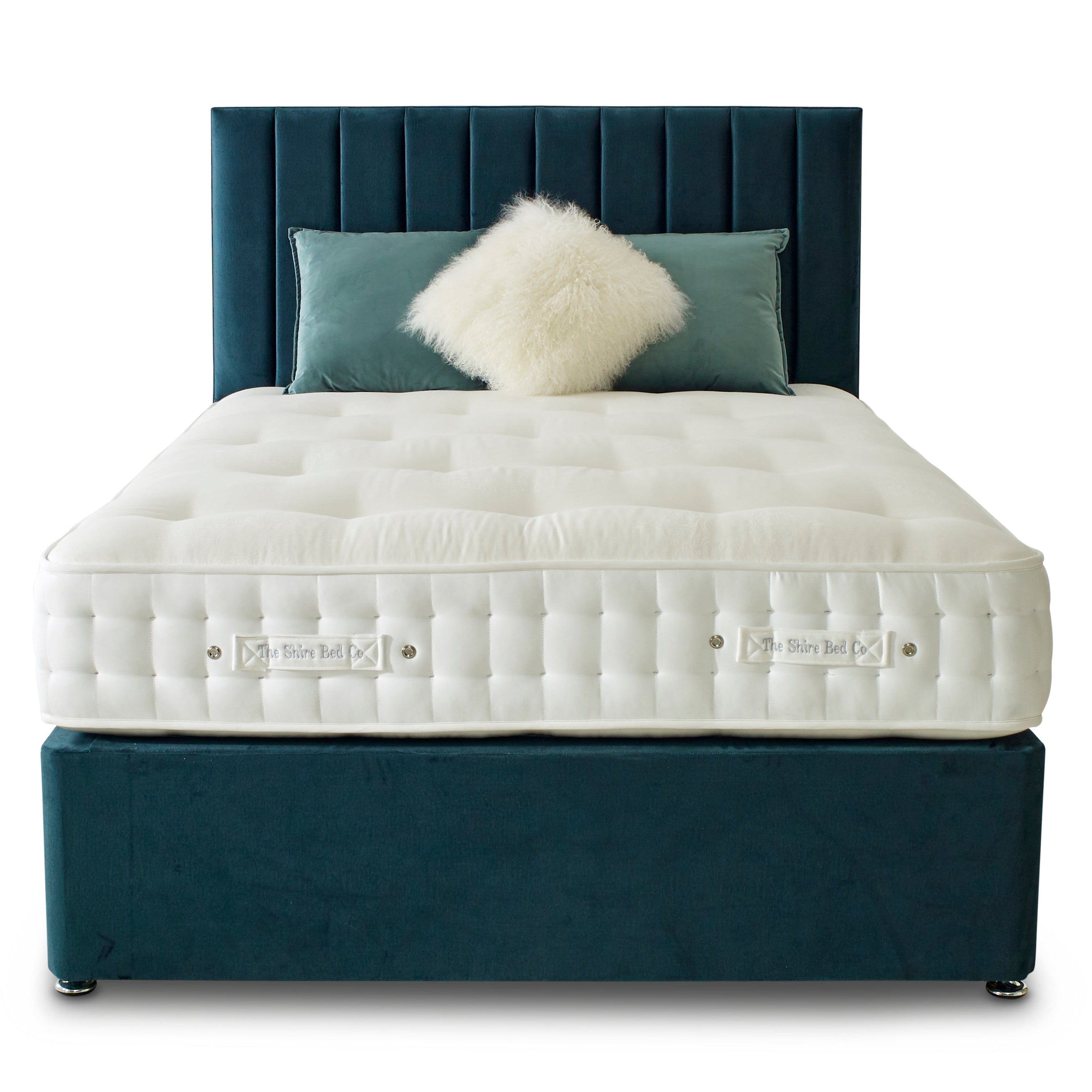 White mattress on a dark blue bed frame with decorative pillows on a white background