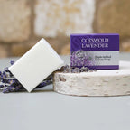 Cotswold Lavender soap bar and packaging on a stone surface with lavender flowers.