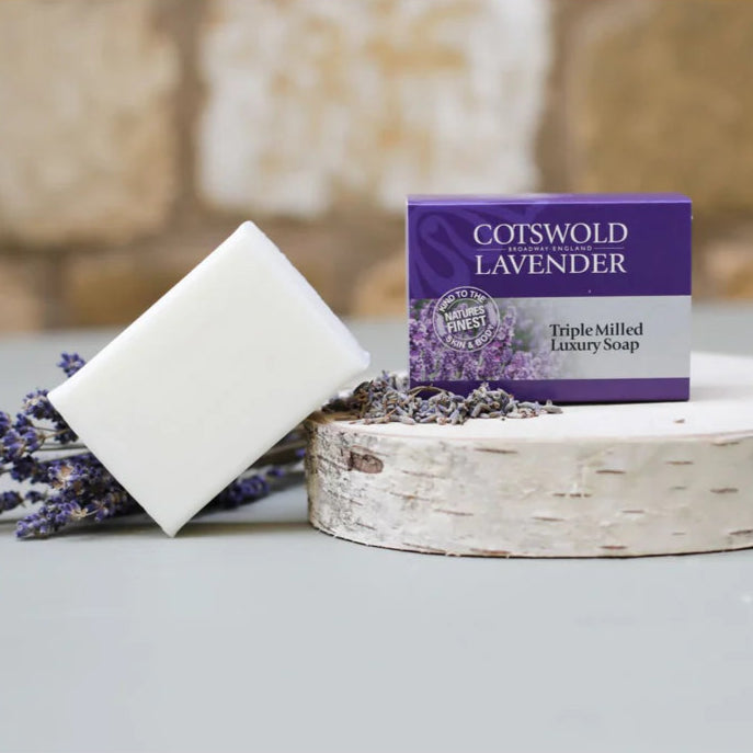 Cotswold Lavender soap bar and packaging on a stone surface with lavender flowers.