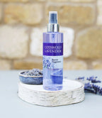 Cotswold Lavender room fragrance bottle on a stone surface with a blurred background