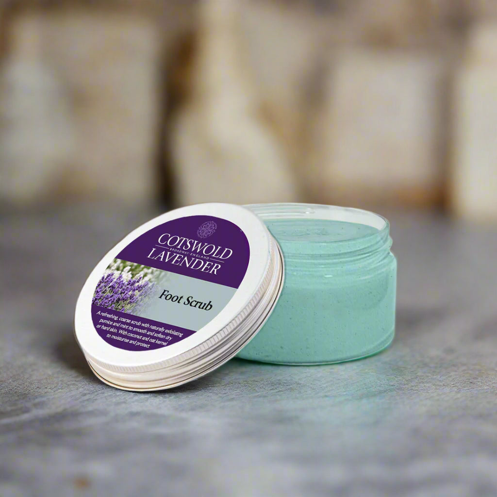 Cosmetic jar of Coiswold Lavender Foot Scrub with a purple label on a white background