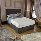 Bedroom with a bed featuring a mattress and pillows, wooden nightstands, and decorative elements.